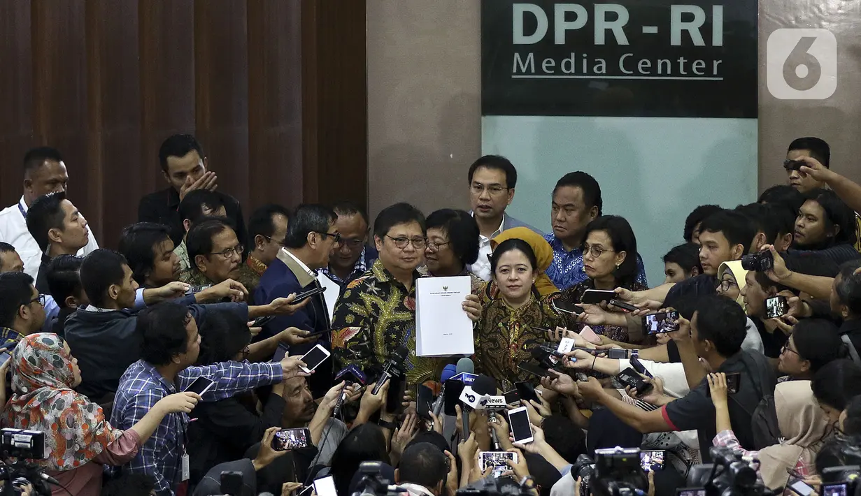 Menko Perekonomian Airlangga Hartarto (tengah) bersama Ketua DPR Puan Maharani menunjukkan draft RUU Omnibus Law di Kompleks Parlemen, Senayan, Jakarta, Rabu (12/2/2020). Pemerintah mengajukan RUU Omnibus Law Cipta Lapangan Kerja dan RUU Omnibus Law Perpajakan. (Liputan6.com/Johan Tallo)
