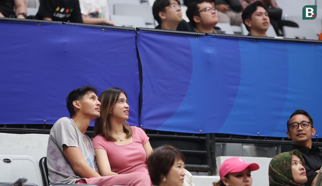 Atlet basket, Daniel Wenas, bersama pevoli putri, Shella Bernadetha, saat menonton langsung pertandingan FIBA World Cup 2023 antara Prancis vs Pantai Gading di Indonesia Arena, Sabtu (2/9/2023). Prancis mengalahkan Pantai Gading dengan skor 87-77. (Bola.com/M Iqbal Ichsan)