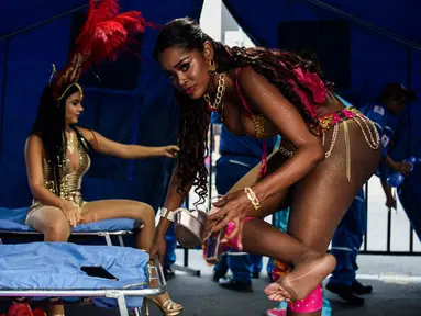 Dua wanita penari salsa Kolombia mempersiapkan diri sebelum tampil dalam pembukaan parade "Salsodromo" Cali Fair ke-61 di Cali, Kolombia (25/12). (AFP Photo/Christian Escobarmora)