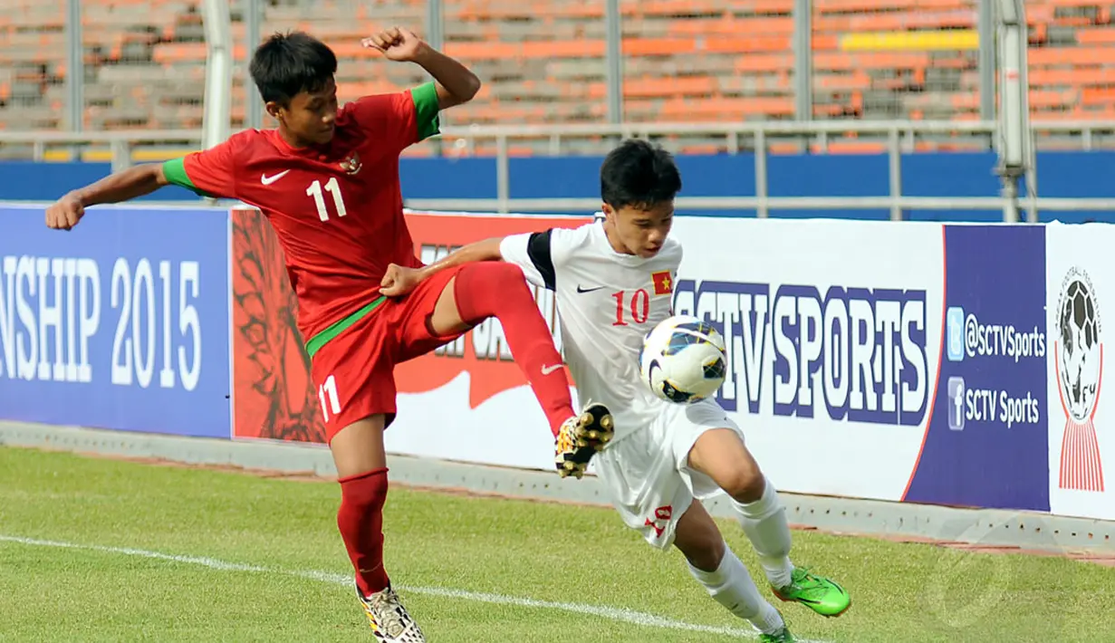 Pemain depan timnas U-16 Indonesia, Drey Buyung (kiri) berebut bola dengan Pham Nhat Chien (Vietnam) pada laga persahabatan di Stadion GBK Jakarta, (3/12/2014). Timnas U-16 Indonesia unggul 3-2 atas Timnas U-16 Vietnam. (Liputan6.com/Helmi Fithriansyah)