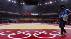 Petugas membersihkan dan mendisinfektan matras sebelum hari kelima kompetisi judo Olimpiade Tokyo 2020 di Nippon Budokan di Tokyo pada Rabu (28/7/2021). Olimpiade yang digelar saat pandemi COVID-19 tersebut menerapkan protokol kesehatan ketat. (Jack GUEZ / AFP)