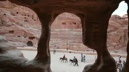 Wisatawan menaiki keledai saat mengunjungi kota arkeologi Petra, Yordania, Kamis (21/11/2019). Bangunan Petra sangat memukai dengan perpaduan gaya Timur dan Helenistik. (AHMAD ABDO/AFP)