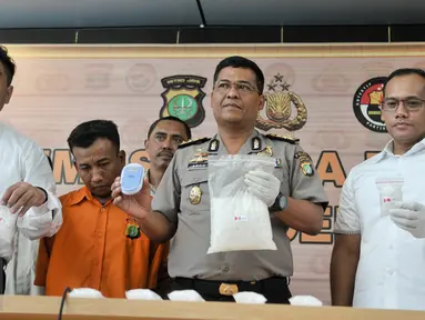 Petugas memperlihatkan barang bukti dan tersangka saat rilis di Polda Metro Jaya, Jakarta, Rabu (22/2). Dari tangan tersangka, Polisi berhasil mengamankan narkotika jenis sabu sebanyak 2,5kg. (Liputan6.com/Yoppy Renato)