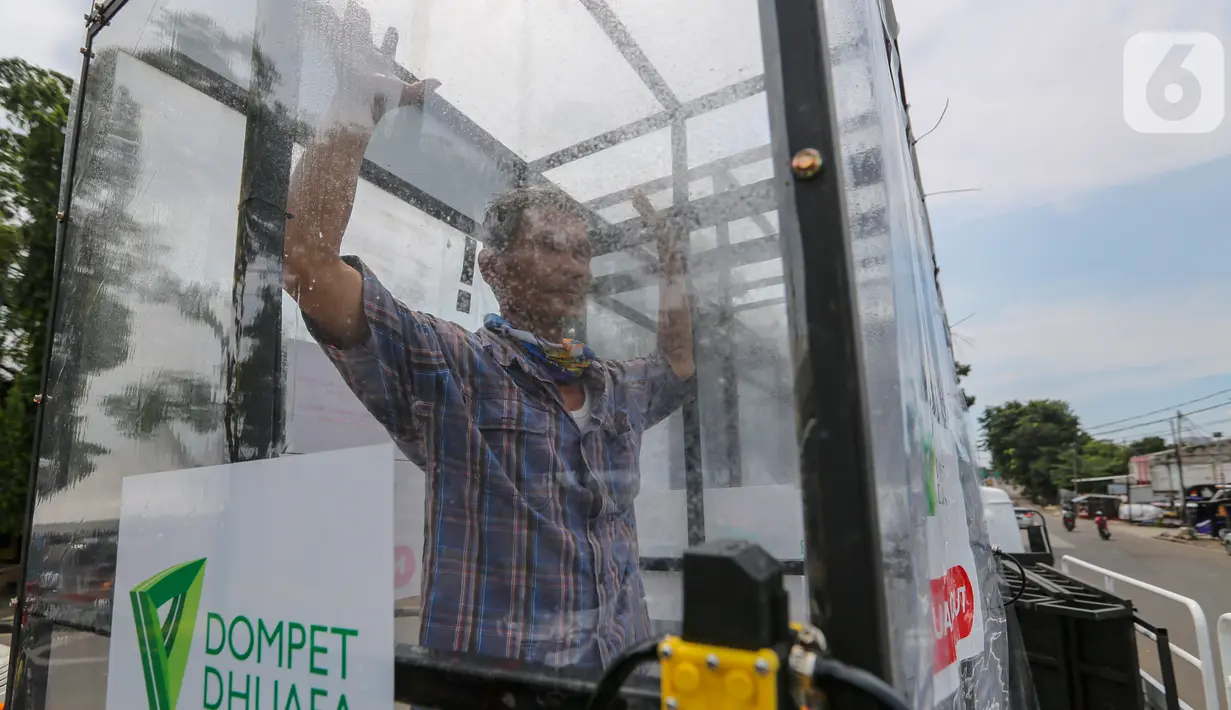 Warga menyemprotkan diri menggunakan cairan antiseptik di bilik disinfektan chamber di CheCk Point PSBB, perbatasan Jakarta - Tangerang Selatan, Pasar Jumat, Kamis (16/4/2020). Bilik disinfektan chamber diperuntukkan bagi masyarakat sekitar selama Corona COVID-19. (Liputan6.com/Fery Pradolo)