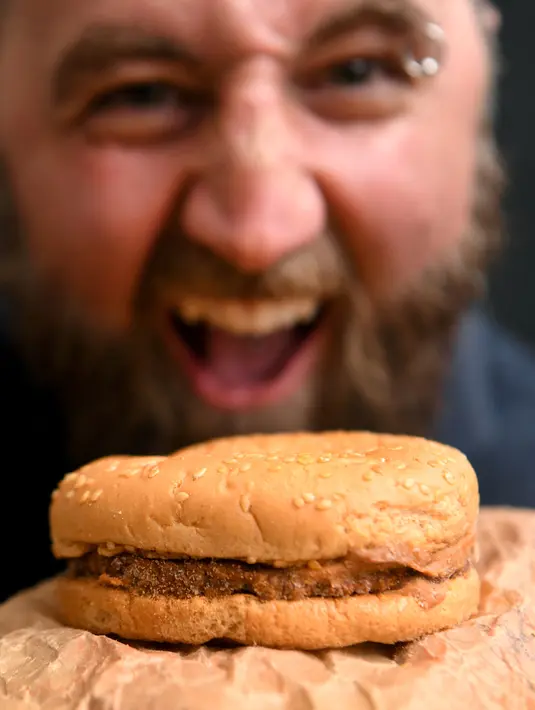 Casey Dean memeriksa burger McDonald's yang dibeli pada 1995 dan disimpan di gudang Australia selama bertahun-tahun, di Melbourne, 7 November 2019. Ini bukan kasus pertama, di Islandia ada burger berusia 10 tahun dari gerai McDonald's terakhir di negara itu yang tutup. (William WEST/AFP)