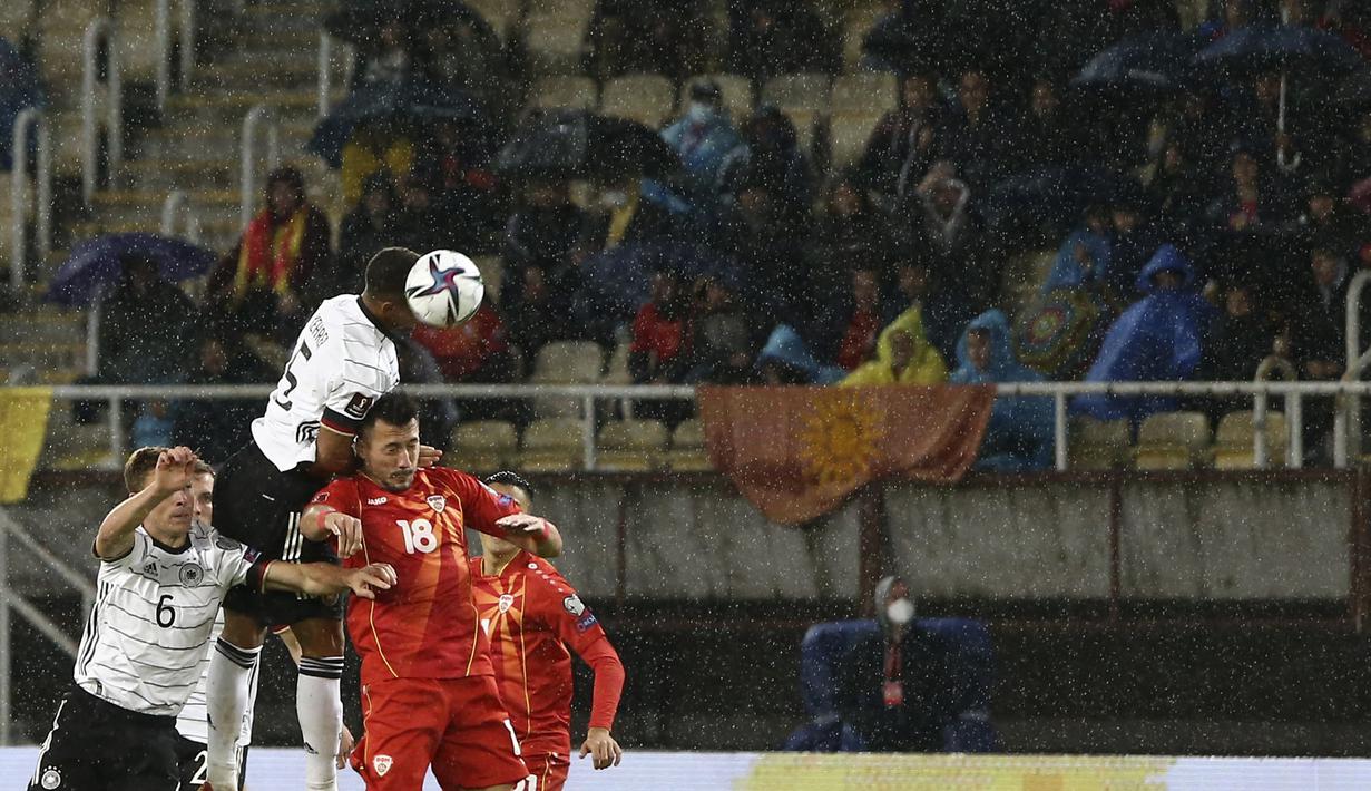 Bek Jerman Thilo Kehrer menyundul bola melewati penyerang Makedonia Utara Adis Jahovic pada lanjutan Kualifikasi Piala Dunia 2022 zona Eropa Grup J di Tose Proeski National Arena, Selasa (12/10/2021) dini hari WIB. Jerman menghajar Makedonia Utara empat gol tanpa balas. (AP Photo/Boris Grdanoski)