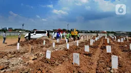 Petugas menurunkan jenazah korban COVID-19 dari ambulans untuk dimakamkan di TPU Rorotan, Cilincing, Jakarta Utara, Kamis (29/4/2021). Dalam sehari, TPU Rorotan memakamkan korban COVID-19 dengan rata-rata 5 hingga 8 jenazah. (merdeka.com/Arie Basuki)