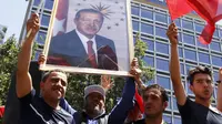 Warga membawa foto Presiden Turki, Tayyip Erdogan sambil mengibarkan bendera nasional mereka di Ankara,  Sabtu (16/7). Ratusan warga turun ke jalan untuk merayakan kegagalan kudeta militer di Turki. (REUTERS/ Tumay Berkin)