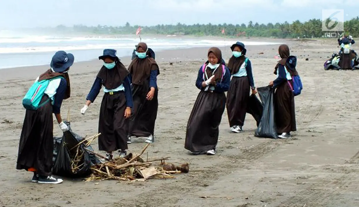 Sejumlah siswi membersihkan pantai dalam program Sekolah Pantai Indonesia (SPI) di pesisir Pantai Barat Pangandaran, Jawa Barat (23/11). Kegiatan Gerakan Cinta Laut oleh KKP menerapkan prinsip dari, oleh dan untuk siswa. (Liputan6.com/KKP)