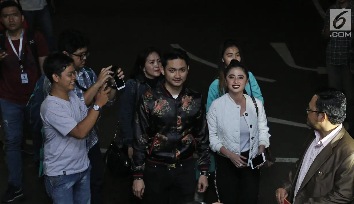 Pedangdut Dewi Persik didampingi suaminya, Angga Wijaya serta pengacara tiba di Polda Metro Jaya, Jakarta, Senin (4/12). Pihak pedangdut Dewi Perssik resmi melaporkan balik petugas Transjakarta bernama Harry Maulana Saputra. (Liputan6.com/Herman Zakharia)