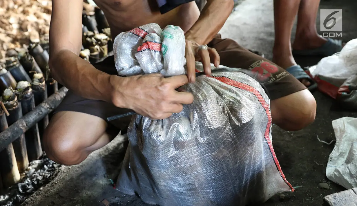 Pekerja membungkus lemang yang siap dijual di kawasan Senen, Jakarta, Selasa (30/5). Memasuki bulan Ramadan, produksi panganan khas dari Sumatera Barat tersebut meningkat 500% yang dijual seharga Rp13.000 perbuah. (Liputan6.com/Immanuel Antonius)