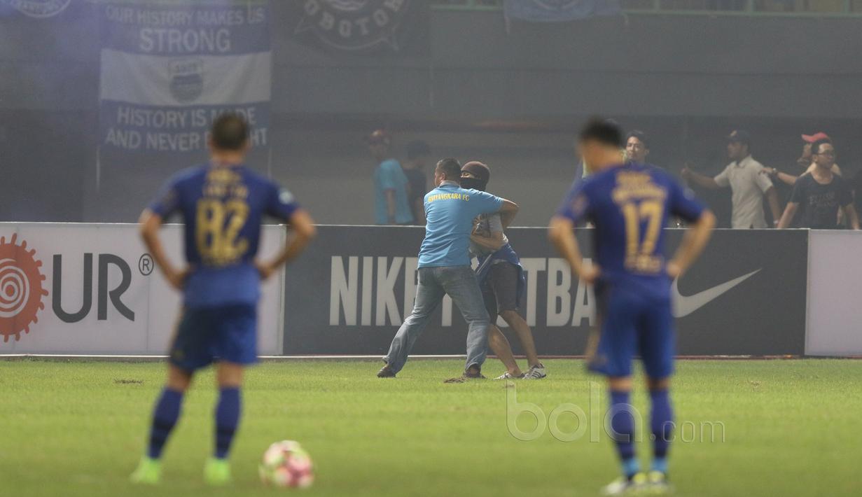 Bobotoh diamankan petugas saat turun ke dalam lapangan pada laga Liga 1 2017  antara Bhayangkara FC melawan Persib Bandung di Stadion Patriot, Bekasi, Minggu (4/6/2017). Persib kalah 0-2. (Bola.com/Nicklas Hanoatubun)