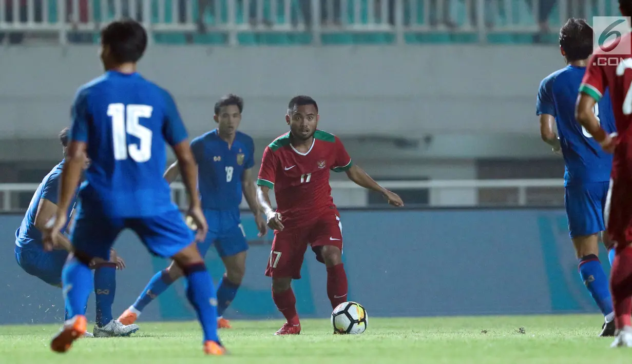 Gelandang Timnas Indonesia U-23, Saddil Ramdani (tengah) mencoba melewati adangan pemain Thailand U-23 pada laga persahabatan di Stadion Pakansari, Kab Bogor, Minggu (3/6). Laga berakhir imbang 0-0. (Liputan6.com/Helmi Fithriansyah)