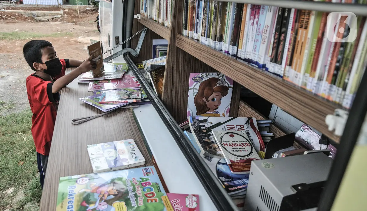 Seorang anak membaca buku di Perpustakaan Keliling kawasan Jatinegara, Jakarta, Rabu (29/9/2021). Mobil Perpustakaan Keliling yang difasilitasi Dinas Perpustakaan dan Kearsipan DKI itu merupakan sarana dan upaya pemerintah dalam meningkatkan minat baca anak sejak dini. (merdeka.com/Iqbal S Nugroho)