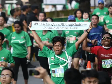 Peserta menunjukkan tulisan saat sampai di garis finis dalam Lomba lari MILO Jakarta International 10K 2017, Jakarta, Minggu (23/7). MILO Jakarta International 10K 2017 melombakan tiga kategori 10K, 5K dan Family Run 1,7K. (Liputan6.com/Faizal Fanani)