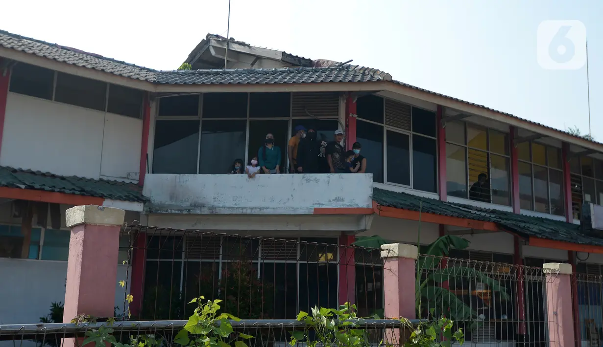 Sejumlah orang menyaksikan pembongkaran pagar beton yang mengisolasi warga di Jalan Akasia, Tajur Ciledug, Tangerang, Banten, Rabu ( 17/3/2021). Pagar beton yang sempat menutup akses jalan warga tersebut kini dibongkar. (merdeka.com/Imam Buhori)