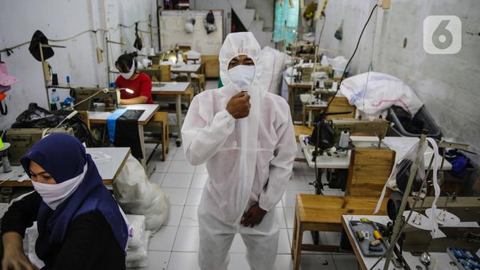 Pekerja memakai pakaian untuk Alat Pelindung Diri (APD) tenaga medis di kawasan Penggilingan, Jakarta, Kamis (26/3/2020). Harga yang dijual untuk APD bekisar antara Rp 45.000 untuk jenis pakaian sekali pakai dan Rp 75.000 untuk pakaian yang bisa dicuci. (Liputan6.com/Faizal Fanani)