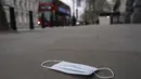 Masker wajah di tanah di Westminster, di London, Kamis (16/12/2021). Inggris mencatat 78.610 infeksi baru pada hari Rabu, 16 persen lebih tinggi dari rekor sebelumnya yang ditetapkan pada Januari. (AP Photo/Alberto Pezzali)