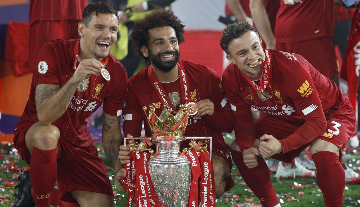 Pemain Liverpool, Mohamed Salah, Xherdan Shaqiri dan Dejan Lovren, saat merayakan trofi juara Premier league 2019-2020 di Stadion Anfield, Kamis (23/7/2020) dini hari WIB. Prosesi angkat trofi juara ini dilakukan usai pertandingan Liverpool melawan Chelsea. (AFP/Phil Noble/pool)