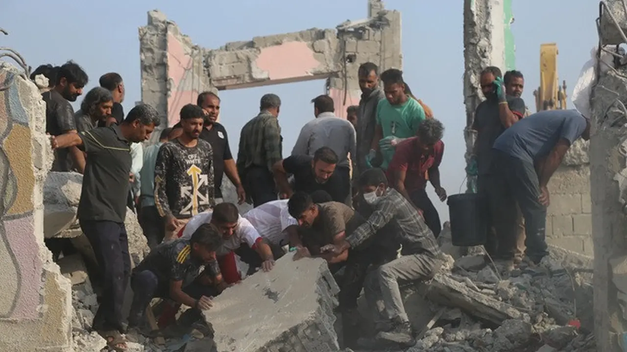 Petugas penyelamat dan warga mencari korban di antara puing-puing bangunan setelah serangan terhadap sebuah sekolah dasar khusus perempuan di Minab, Iran, Sabtu (28/2/2026).
