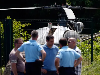 Aparat kepolisian berdiri dekat helikopter yang ditinggalkan seorang gangster terkenal Prancis, Redoine Faid di Gonesse, utara Paris, Minggu (1/7). Faid (46) kabur dari penjara di Reau dengan dijemput helikopter tersebut. (AFP/GEOFFROY VAN DER HASSELT)