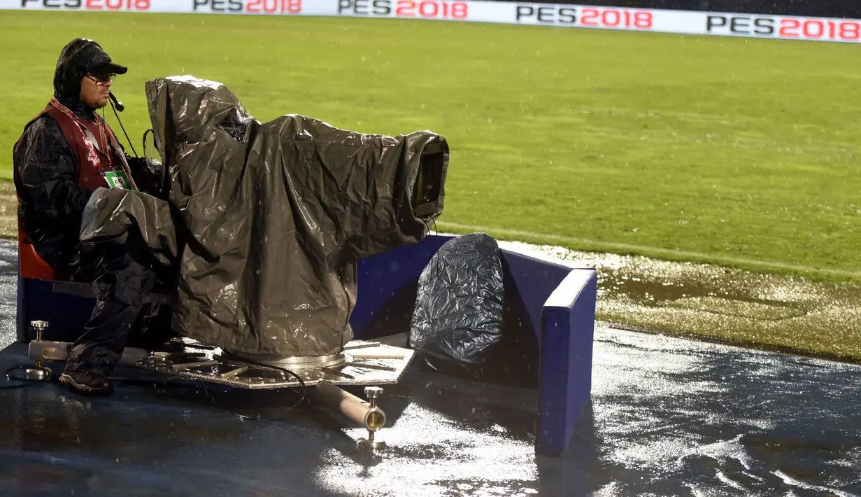 Kameramen sedang mengambil gambar Kroasia melawan Kosovo saat hujan deras pada laga Grup I kualifikasi Piala Dunia 2018 di Stadion Maksimir, Zagreb, (2/9/2017).  Laga tersebut diberhentikan wasit karena stadion penuh genangan air. (AFP/ STR)