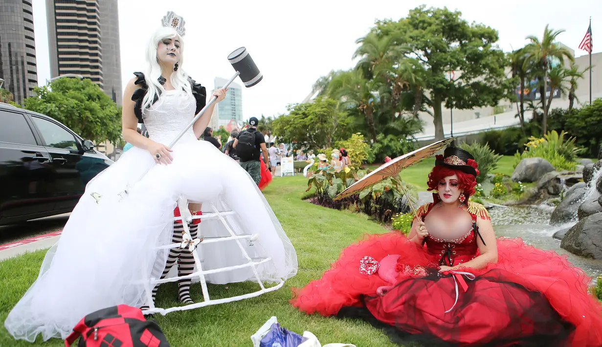 Cosplay berpakaian White Queen dan Queen of Hearts berpose di luar San Diego Comic-Con, San Diego, California, Amerika Serikat, Jumat (20/7). (Mario Tama/Getty Images/AFP)