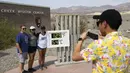 Turis berpose dekat termometer yang menunjukkan suhu 129 Derajat Fahrenheit (54 Derajat Celcius) di Pusat Pengunjung Furnace Creek di Taman Nasional Death Valley, California, Kamis (17/6/2021). Sebagian besar AS bagian barat bersiap menghadapi rekor gelombang panas minggu ini. (Patrick T. FALLON/AFP
