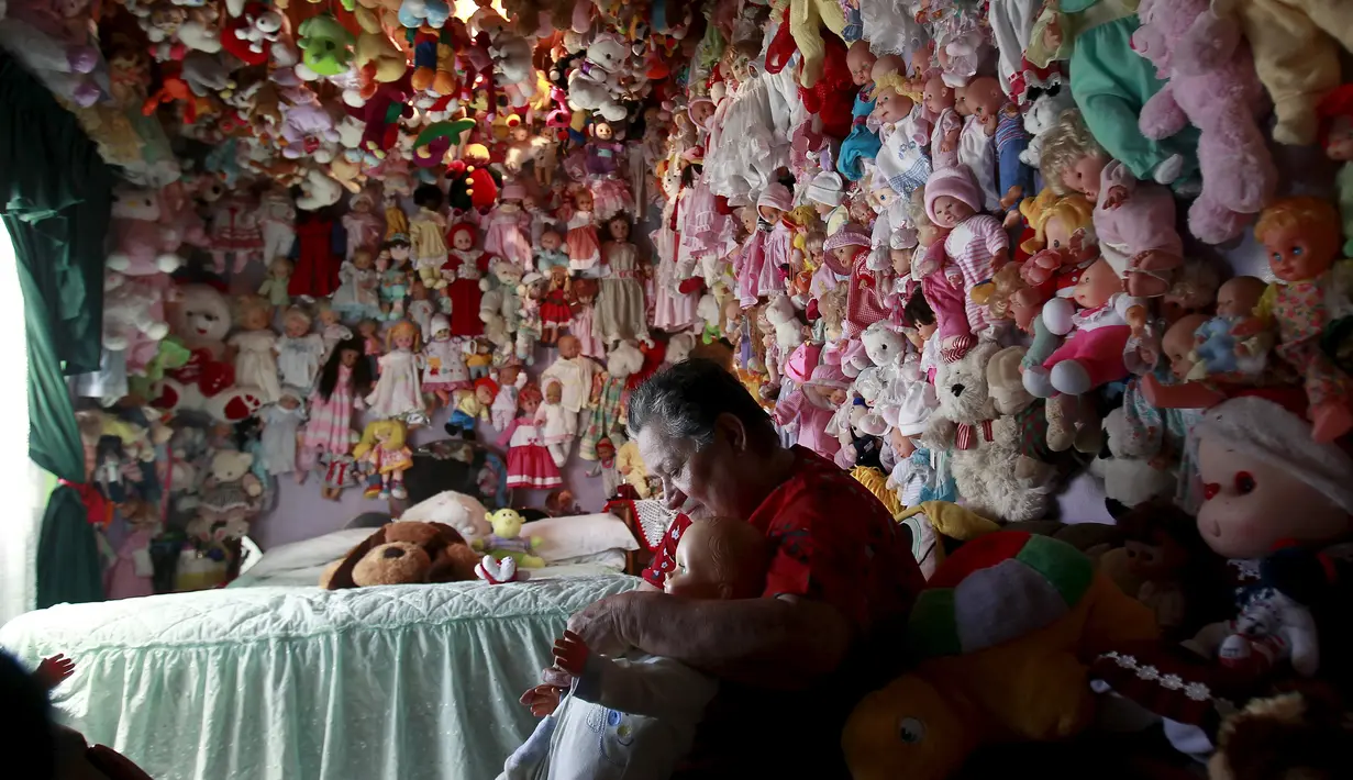 Adela Rojas saat bermain dengan boneka miliknya di Heredia, Costa Rica (5/8/2015). Rojas telah mengumpulkan boneka selama lebih dari dua puluh tahun dan sekarang memiliki lebih dari 4.500 boneka. (REUTERS/Juan Carlos Ulate)