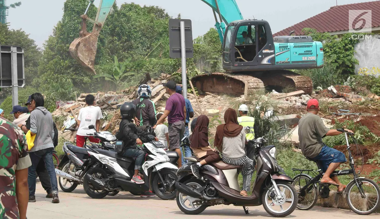 Warga menyaksikan alat berat mengeksekusi bangunan rumah milik warga yang terdampak proyek Jalan Tol Cijago Seksi II sepanjang 5,5 km di kawasan Kukusan, Depok, Jawa Barat, Rabu (12/12). (Liputan6.com/Immanuel Antonius)