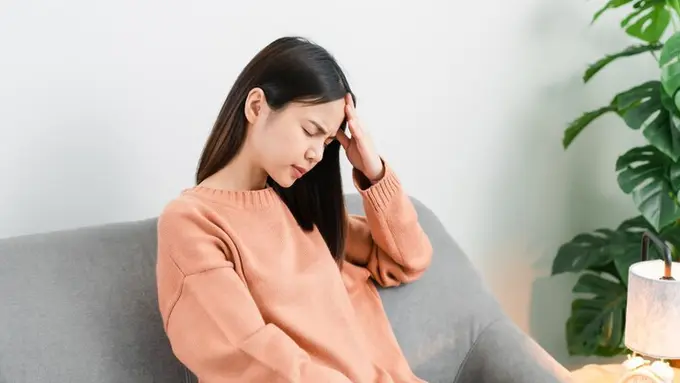 Seorang perempuan memegang kepalanya karena migrain (Foto Dok: Freepik/sitthiphong)