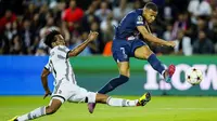 Pemain Juventus, Juan Cuadrado, berusaha menghalau bola tendangan penyerang PSG, Kylian Mbappe pada laga Liga Champions di Stadion Parc des Princes, Paris, Rabu (7/9/2022). (AP/Thibault Camus)