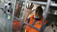 Mantan Hakim Konstitusi, Patrialis Akbar melambaikan tangan dari dalam mobil tahanan usai menjalani pemeriksaan di gedung KPK, Jakarta, Selasa (23/5). KPK hari ini melimpahkan seluruh berkas dan tersangka ke penuntut umum. (Liputan6.com/Helmi Afandi)