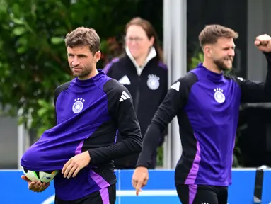 Penyerang Jerman #13 Thomas Mueller dan penyerang Jerman #09 Niclas Fullkrug mengambil bagian dalam sesi latihan MD-1 menjelang laga perempat final Euro 2024 di base camp tim di Herzogenaurach, Kamis (4/7/2024). (Tobias SCHWARZ / AFP)