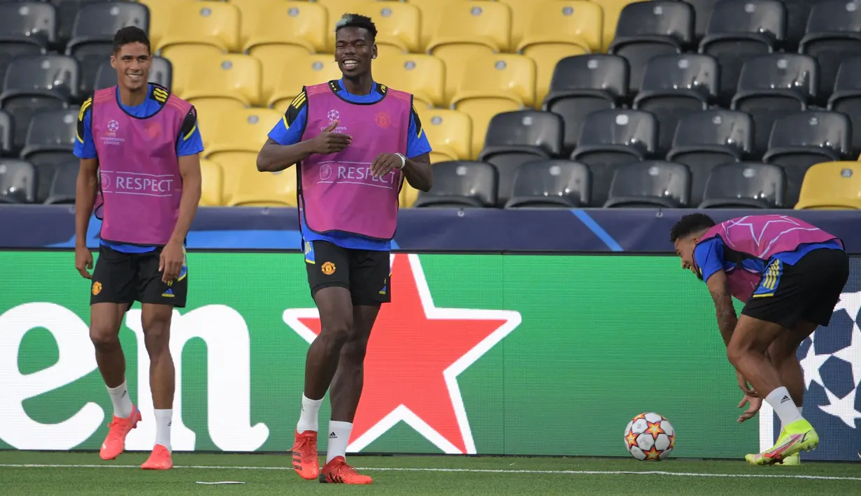 Bek Manchester United Prancis Raphael Varane (kiri), gelandang Paul Pogba (kedua dari kiri) dan Jesse Lingard ambil bagian dalam sesi latihan di Bern (13/9/2021). Manchester United akan bertanding melawan Young Boys pada Grup F Liga Champions di Stadion Wankdorf. (AFP/Sebastien Bozon)