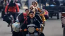 Dengan mengendarai sepeda motor pengungsi Palestina bergerak menuju daerah yang lebih aman setelah dimulainya kembali serangan Israel di Rafah di Jalur Gaza Selatan pada 1 Desember 2023. (MAHMUD HAMS/AFP)