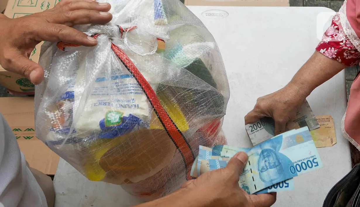 Warga membeli sembako murah di Kantor Kelurahan Cililitan, Jakarta, Rabu (2/2/2022). Pasar murah ini menyediakan minyak goreng dengan harga subsidi yakni Rp 14.000 per liter, beras 5kg dengan harga Rp 55.000 serta telur, susu UHT, gula pasir dan tepung terigu. (Liputan6.com/Herman Zakharia)