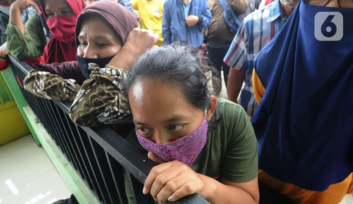 Warga menunggu giliran menerima uang Bantuan Sosial Tunai (BST) bulan Januari di halaman Masjid Jami Al-Hidayah RW 01 Bedahan, Depok, Selasa (16/2/2021). Sekitar 159.470 Keluarga Penerima Manfaat di Kota Depok menerima BST yang disalurkan PT Pos Indonesia pada Februari ini. (merdeka.com/Arie Basuki)