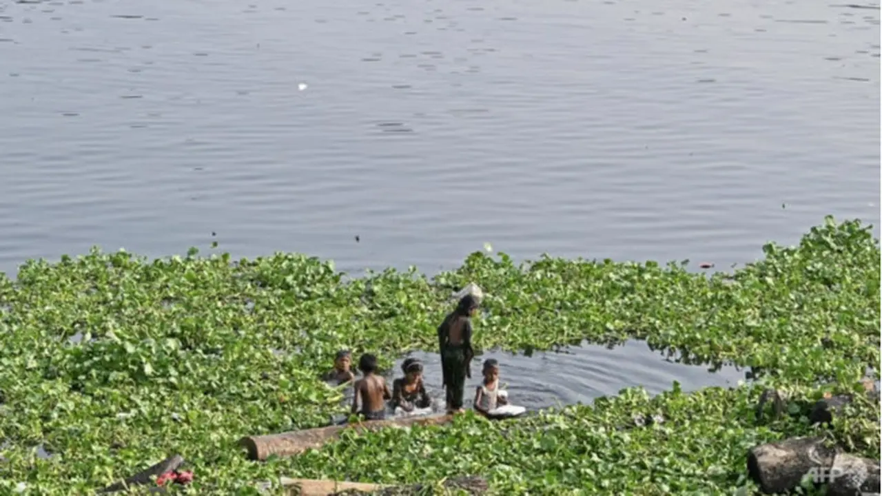 Anak-anak mandi di sungai Buriganga pada musim panas yang terik di Dhaka pada 19 April 2023. (AFP/Munir Uz Zaman)