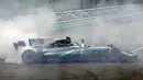 Aksi pebalap Mercedes, Valtteri Bottas melakukan drifting usai meraih podium pada balapan F1 Abu Dhabi di Yas Marina circuit , (26/11/2017). Bottas finis pertama. (AFP/Karim Sahib)