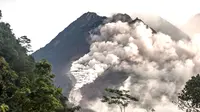 Orang-orang melihat Gunung Merapi yang memuntahkan batu dan abu di Yogyakarta (27/1/2021).  Potensi bahaya saat ini berupa guguran lava dan awan panas pada sektor selatan-barat daya meliputi sungai Boyong, Bedog, Krasak, Bebeng, dan Putih sejauh maksimal 5 kilometer.  (AFP/ Agung Supriyanto)
