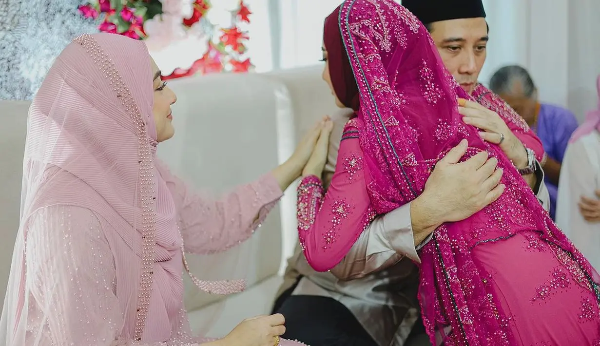 Acara pengajian digelar di rumah, ruangan dihias dengan dekorasi bunga-bunga bernuansa magenta.