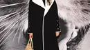 Hadir juga Rashida Jones mengenakan crepe wrap coat, crepe polo dress, teardrop earrings, chain pump, dan polished swing bag.