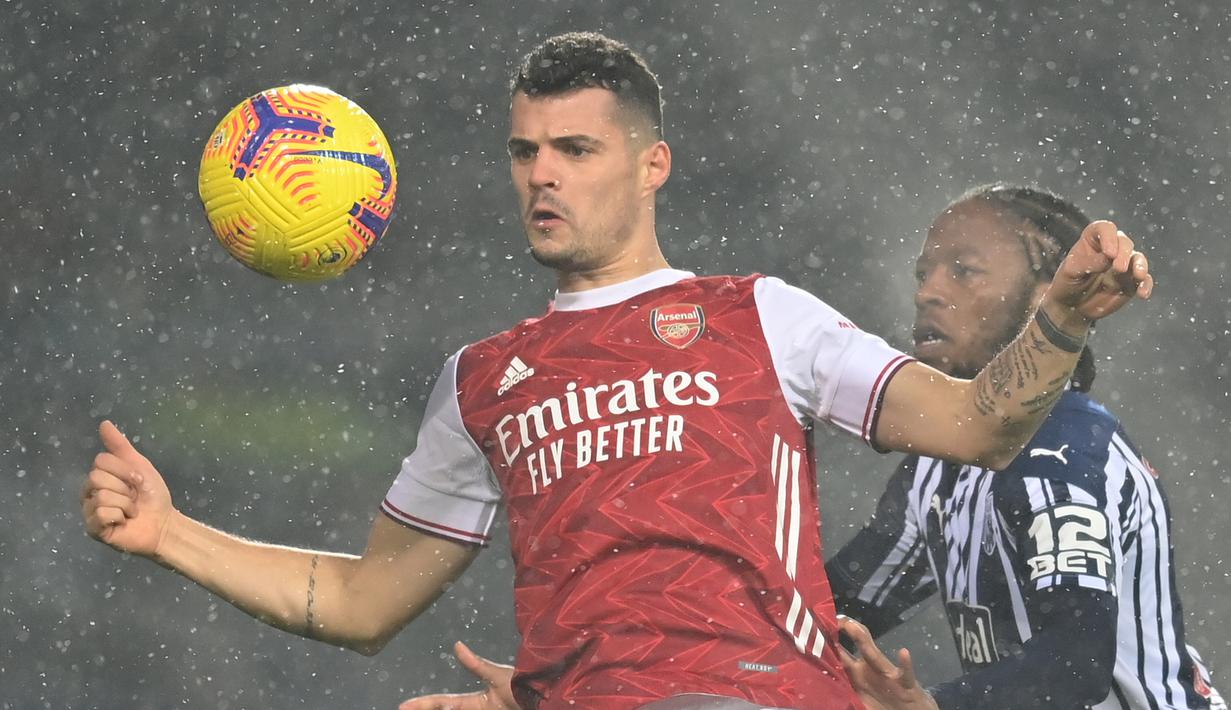Gelandang Arsenal, Granit Xhaka (kiri) berebut bola dengan gelandang West Bromwich Albion, Romaine Sawyers dalam laga lanjutan Liga Inggris 2020/21 pekan ke-17 di Hawthorns Stadium, Sabtu (2/1/2021). Arsenal menang 4-0 atas West Bromwich Albion. (AFP/Michael Regan/Pool)