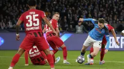 Pemain Napoli, Piotr Zielinski, berusaha melewati pemain Eintracht Frankfurt pada laga Liga Champions di Stadion Diego Armando Maradona, Kamis (16/3/2023). Napoli menang dengan skor 3-0. (AP Photo/Gregorio Borgia)