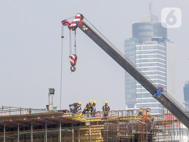 Pekerja menyelesaikan proyek pembangunan Light Rail Transit (LRT) Jabodebek di ruas Jalan Rasuna Said, Jakarta, Jumat (7/8/2020). Salah satu proyek PT Adhi Karya, LRT Jabodebek, ditargetkan selesai pada Juni 2022 di tengah pandemi COVID-19. (Liputan6.com/Fery Pradolo)
