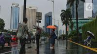 Warga menggunakan payung saat hujan mengguyur kawasan Jakarta, Senin (3/2/2020). Badan Meteorologi, Klimatologi, dan Geofisika (BMKG) merilis informasi peringatan dini cuaca ekstrem yang diperkirakan berlangsung hingga Rabu (5/2/2020) mendatang. (Liputan6.com/Angga Yuniar)