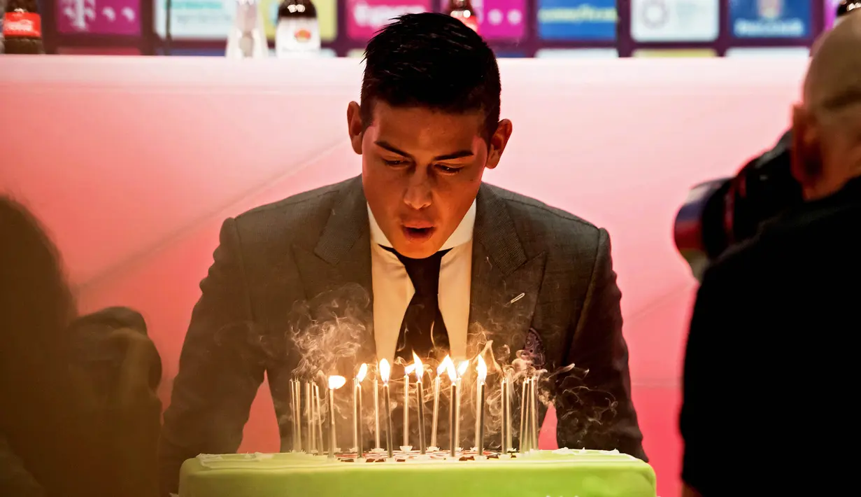 Pemain baru Bayern Munchen, James Rodriguez, mendapatkan suprise kue ulang tahun saat perkenalan dirinya di Munchen, Rabu (12/7/2017). (EPA/Lukas Barth)