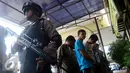 Polisi dengan senjata lengkap menjaga para tersangka saat rilis di halaman Polres Metro Pelabuhan Tanjung Priok, Kamis (27/10). (Liputan6.com/Gempur M. Surya)
