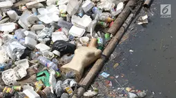 Sebuah manekin terlihat di antara tumpukan sampah di Kali Cideng, Jakarta Pusat, Senin (11/9). Selain penampakannya yang tidak nyaman dipandang, bau yang menyengat juga mengganggu warga yang melintas di kawasan tersebut. (Liputan6.com/Immanuel Antonius)